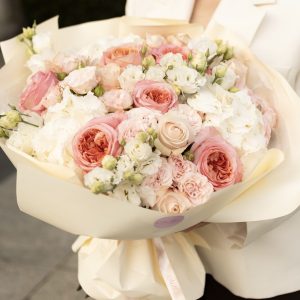 Bukiet „Delikatna elegancja” Kompozycja pełna subtelności i klasy. Pudrowe róże, białe eustomy i hortensje tworzą harmonijną całość, która zachwyca miękkością kolorów i starannością wykonania. To bukiet, który idealnie sprawdzi się na urodziny, ślub, rocznicę lub jako gest wdzięczności — bez okazji